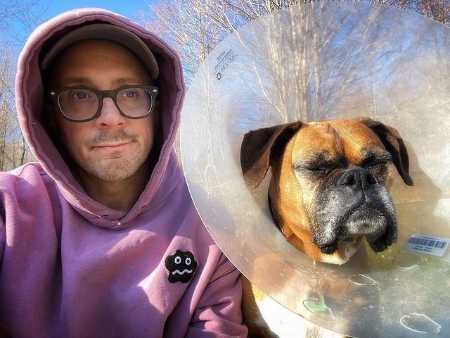 Steve Burns smiling in a violet hoodie with his pet Mickey.